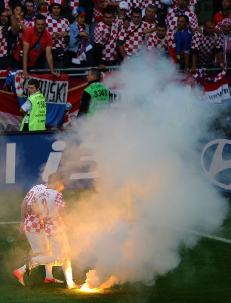 Hai cầu thủ Croatia là Ivan Perisic và Ognjen Vukojevic chạy lại dập lửa.